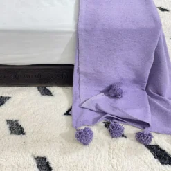 Purple cotton throw styled with artistic and eclectic home accessories