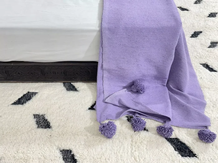 Purple cotton throw styled with artistic and eclectic home accessories