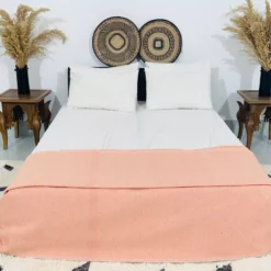 Moroccan pompom throw styled on a boho-style bed in a cozy bedroom