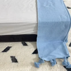 Light blue Moroccan throw casually placed over a reading chair