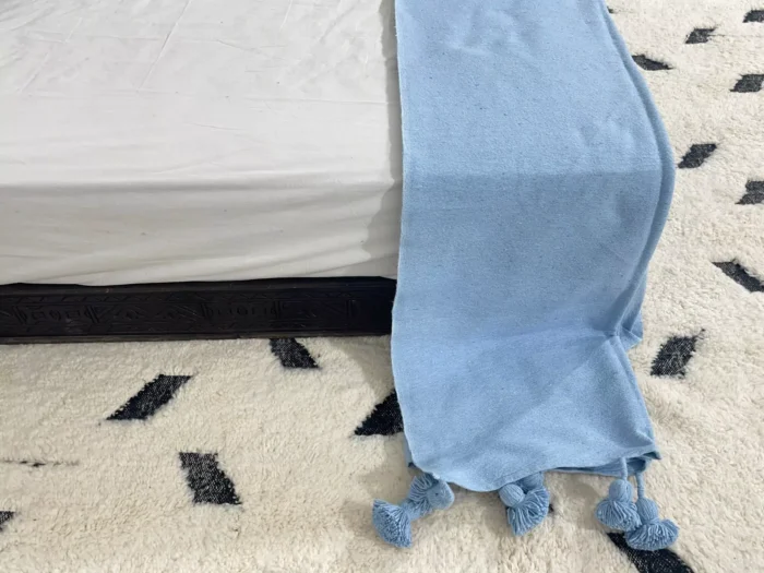 Light blue Moroccan throw casually placed over a reading chair