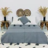 Handmade Moroccan pompom blanket in solid grey, styled on a bed