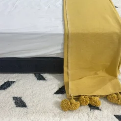 Overview of the Moroccan blanket in mustard with folded sizing shown