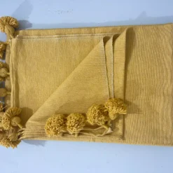 Close-up of the soft cotton weave on mustard throw blanket