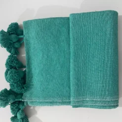 Fabric tag displaying 100% cotton content on teal Moroccan blanket