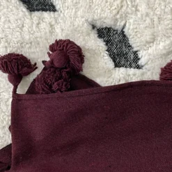 Burgundy pompom throw with Moroccan home accessories and décor