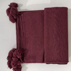 Moroccan burgundy blanket casually draped over a reading chair