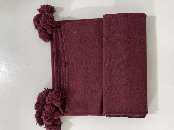 Moroccan burgundy blanket casually draped over a reading chair