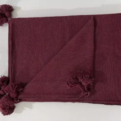 Moroccan cotton throw in burgundy displayed on a cozy modern sofa