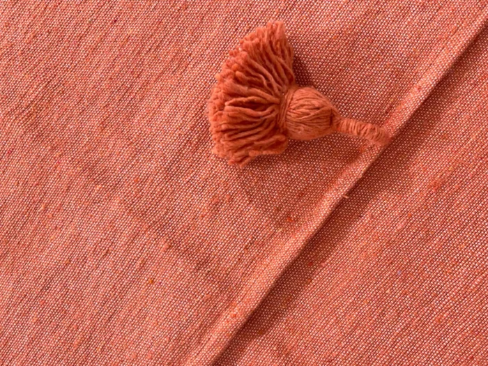 Close-up of woven cotton texture in terracotta color