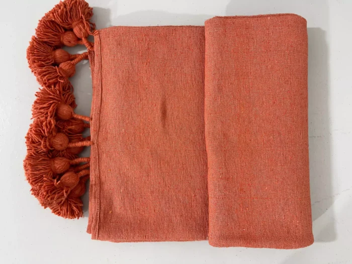 Moroccan terracotta blanket folded to show sizing and texture