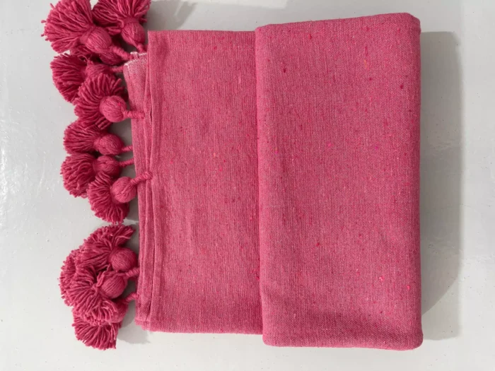 Moroccan pink cotton throw surrounded by neutral and feminine décor