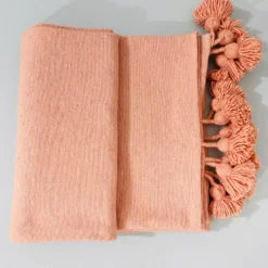 Salmon throw blanket displayed with Moroccan decor accessories