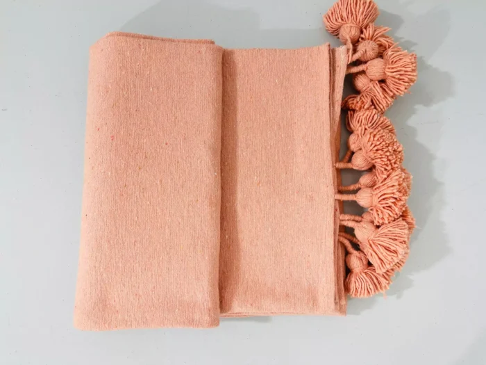 Salmon throw blanket displayed with Moroccan decor accessories