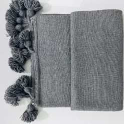 Folded Moroccan grey blanket showing size and label