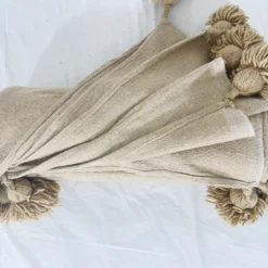 Beige throw blanket in natural light, showing texture and softness