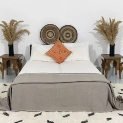 Moroccan taupe pompom blanket styled in a minimalist bedroom