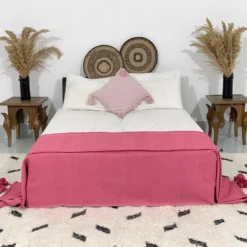 Rose pink pompom blanket styled in a romantic boho bedroom