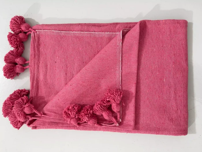 Pink cotton blanket catching natural sunlight
