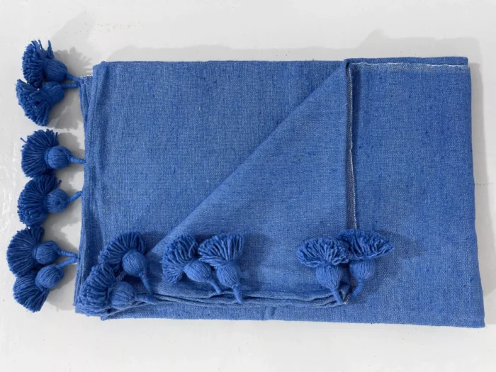 Moroccan blanket in royal blue displayed with artisan decor accessories