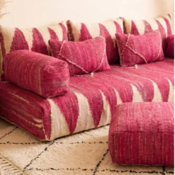 Close-up of pink Moroccan floor sofa armrest and matching pillows