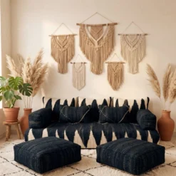 Black Moroccan floor sofa cover set with ivory patterns, matching cushions, armrests, and two poufs