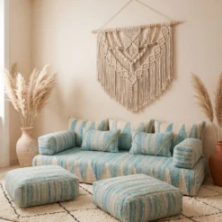 Light blue and ivory Moroccan floor sofa with armrests and matching floor poufs on a diamond-patterned rug