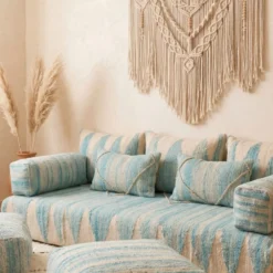 Close-up of light blue Moroccan floor sofa armrest and matching striped pillows