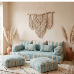 Handwoven light blue and ivory Moroccan floor sofa with large macrame wall hanging and pampas grass