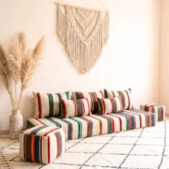 Multicolor striped Moroccan floor sofa with matching pouf viewed from a side angle