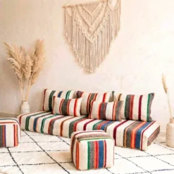 Multicolor striped Moroccan floor sofa with two matching floor poufs on a diamond rug