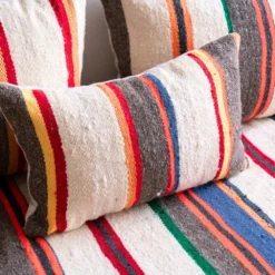 Close-up of handwoven multicolor striped wool fabric on Moroccan floor sofa pillow