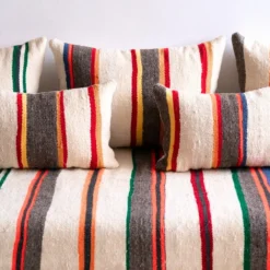 Close-up of multicolor striped Moroccan floor sofa pillows in red, green, blue, and orange