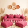 Handwoven pink and ivory Moroccan floor sofa with matching poufs and woven wall baskets