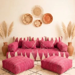 Handwoven pink and ivory Moroccan floor sofa with matching poufs and woven wall baskets