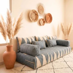 Gray and ivory Moroccan floor sofa viewed from a side angle with terracotta vase