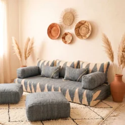 Gray Moroccan floor sofa in a sunlit room with sheer curtains and terracotta vase
