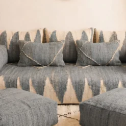 Close-up of gray and ivory Moroccan floor sofa pillows and matching floor poufs
