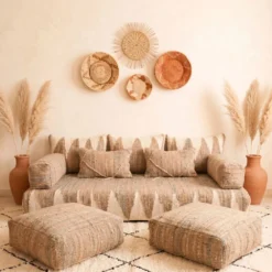Natural beige and ivory Moroccan floor sofa centered beneath woven wall baskets and pampas grass