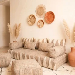 Natural beige and ivory Moroccan floor sofa styled with terracotta vase and woven wall decor