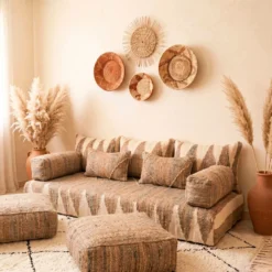 Natural beige and ivory Moroccan floor sofa styled with terracotta vase and woven wall decor