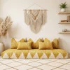 Yellow and ivory Moroccan floor sofa with matching pillows in a living room with arched shelving