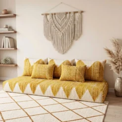 Yellow and ivory Moroccan floor sofa in a cozy corner with wooden shelves and pampas grass