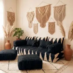 Black and ivory modular floor sofa covers with wool cushions and poufs in a bohemian living room