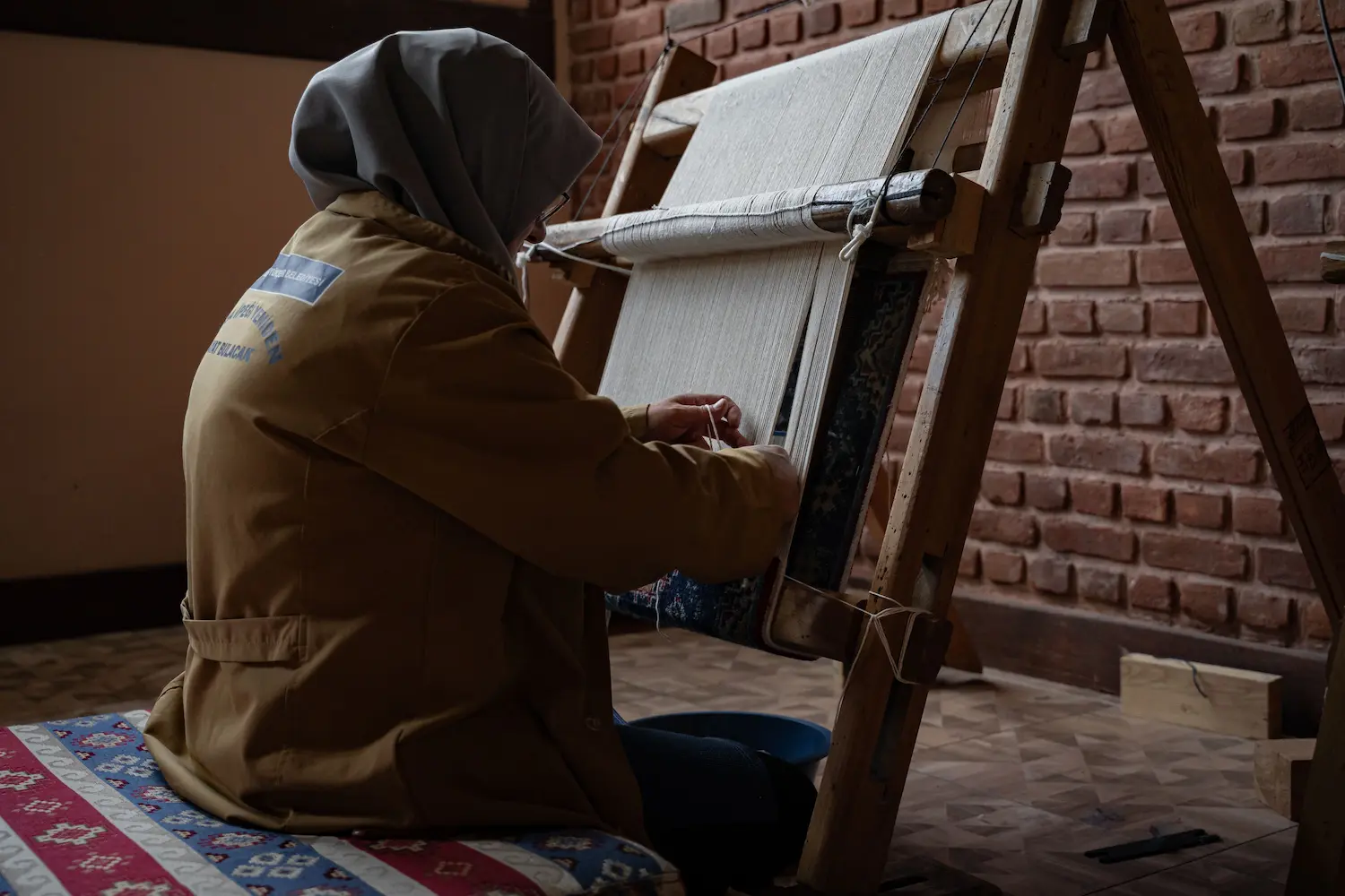 Moroccan artisan weaving textiles on a traditional loom