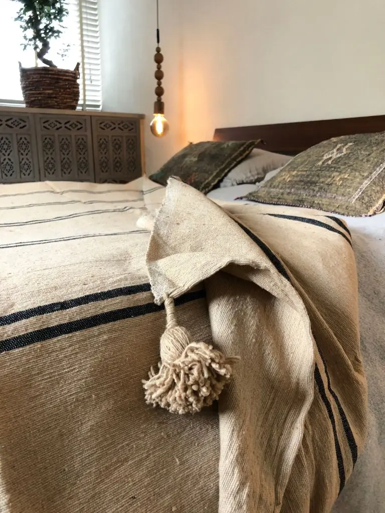 Close-up detail of a handmade Moroccan pompom blanket
