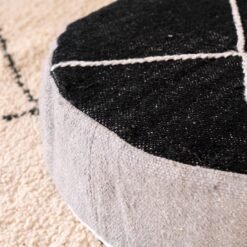 Close-up of black top and grey side panel on a cotton pouf with ivory lines