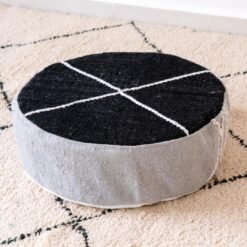 Round cotton pouf with a black top, light grey sides and ivory cross lines
