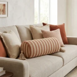 Long brown striped bolster cushion cover styled on cream sofa