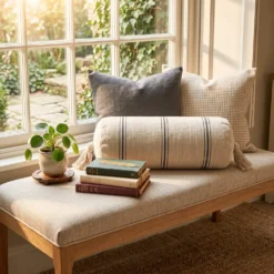 Cream and black striped bolster pillow styled on a window seat